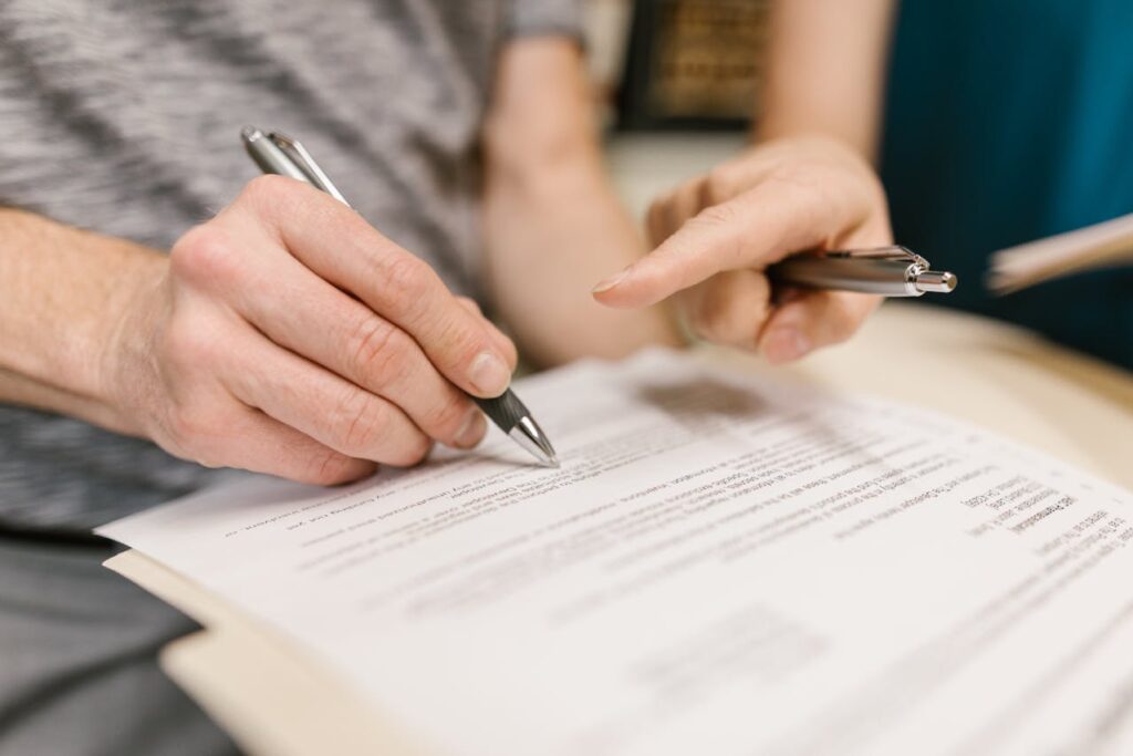 Two People Holding Ballpens